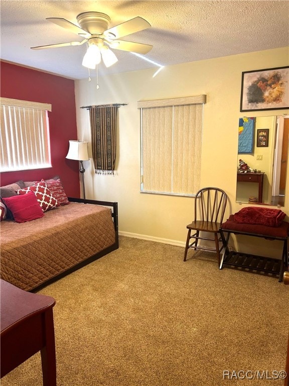 bedroom featuring carpet flooring, ceiling fan, and a textured ceiling