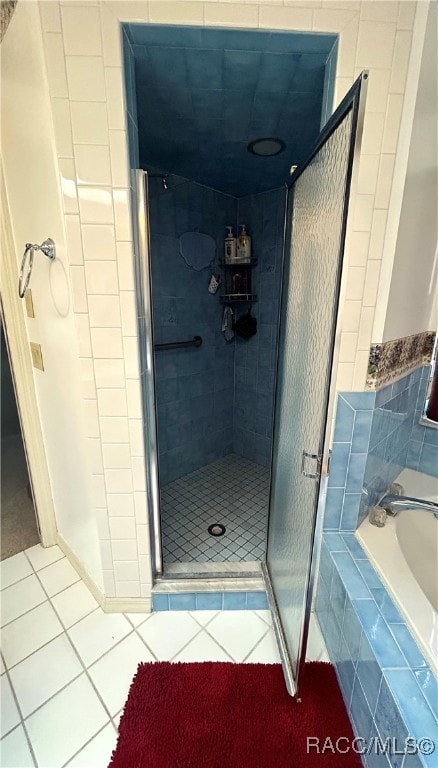 bathroom featuring tile patterned floors and shower with separate bathtub