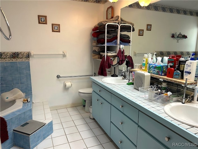 bathroom featuring tiled tub, tile patterned flooring, vanity, and toilet