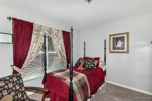 bedroom with carpet, a textured ceiling, and baseboards