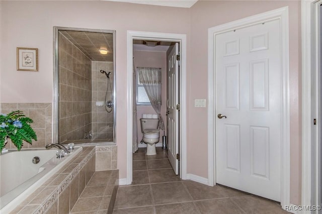 bathroom featuring a garden tub, toilet, a shower stall, baseboards, and tile patterned floors