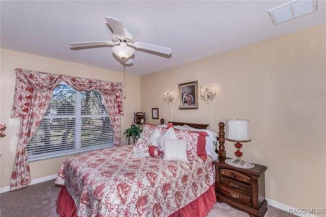 carpeted bedroom featuring a ceiling fan, visible vents, a textured ceiling, and baseboards