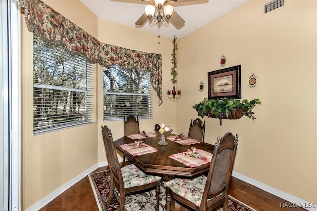 dining space with a ceiling fan, visible vents, dark wood finished floors, and baseboards