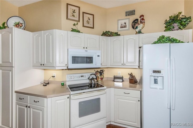 kitchen with visible vents, light countertops, white appliances, and white cabinetry