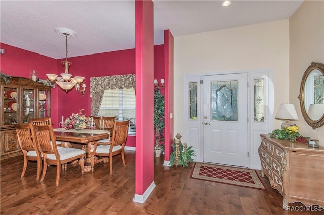 entryway with dark wood-style floors and a notable chandelier