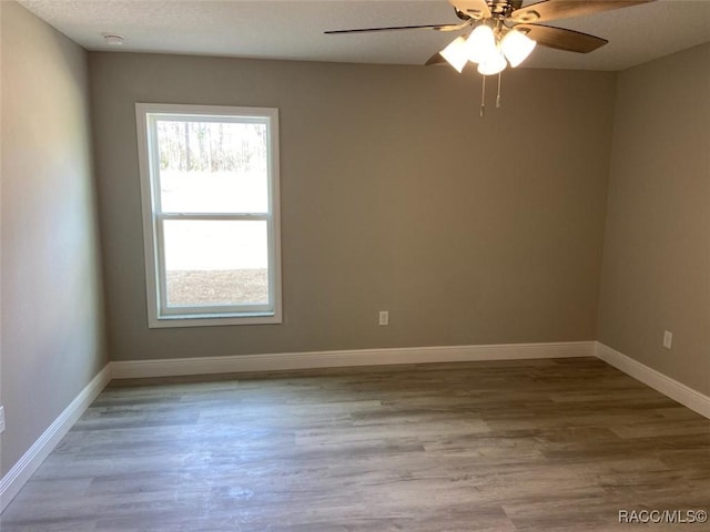 empty room featuring ceiling fan, light hardwood / wood-style flooring, and a textured ceiling