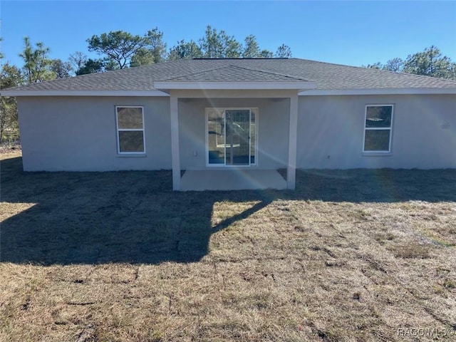 back of house with a patio area and a lawn