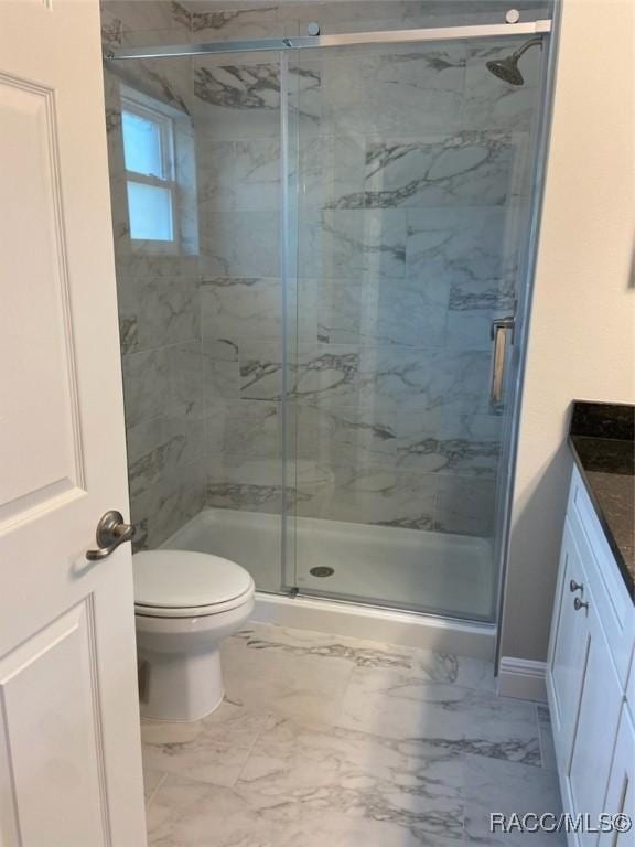 bathroom featuring vanity, toilet, and an enclosed shower