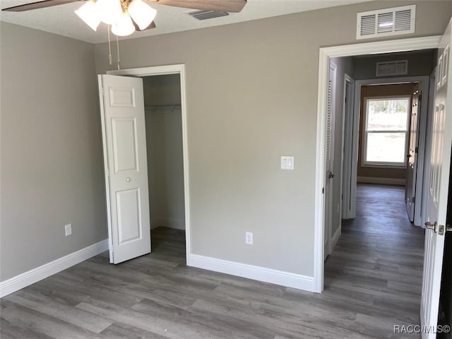 unfurnished bedroom featuring hardwood / wood-style floors, a closet, and ceiling fan