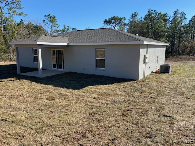 back of property with central AC, a yard, and a patio area