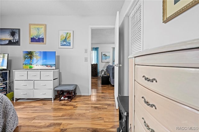 bedroom with a textured ceiling and wood-type flooring