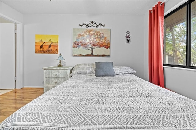 bedroom featuring wood-type flooring and multiple windows