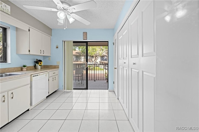 kitchen with a textured ceiling, white cabinetry, dishwasher, and light tile patterned flooring