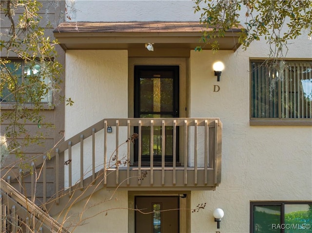 view of exterior entry with a balcony