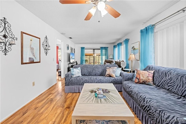 living room featuring hardwood / wood-style floors and ceiling fan