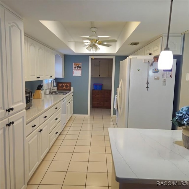 kitchen featuring decorative light fixtures, white cabinetry, sink, a tray ceiling, and white appliances