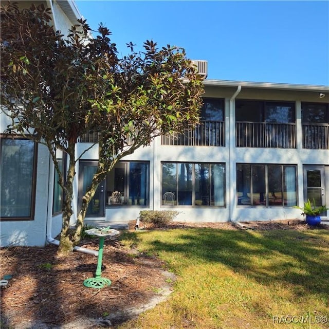 rear view of property featuring a lawn