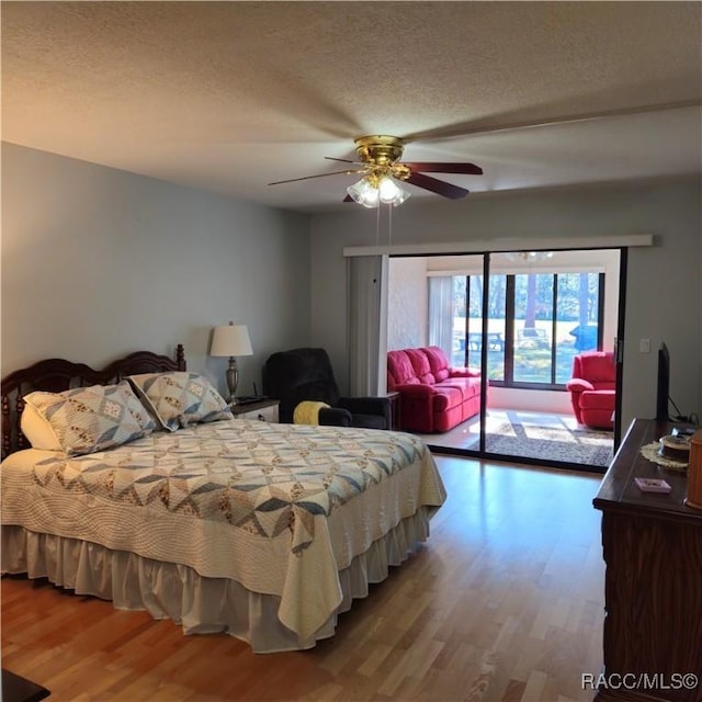 bedroom with access to exterior, hardwood / wood-style flooring, a textured ceiling, and ceiling fan