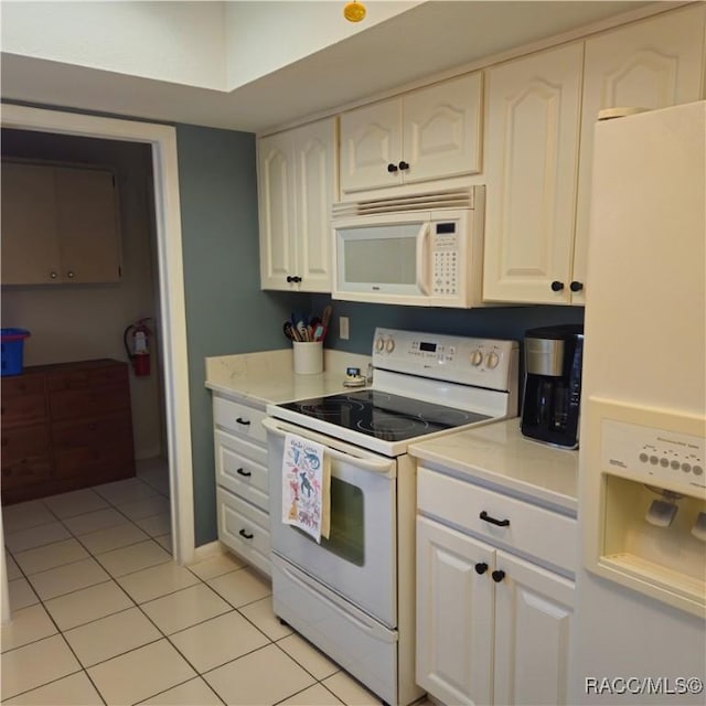 kitchen with white cabinetry, light tile patterned floors, and white appliances