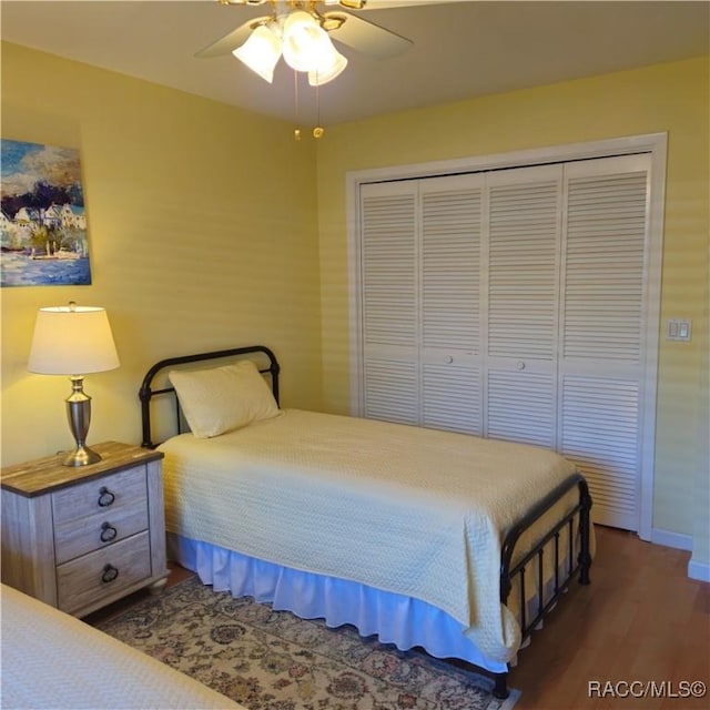 bedroom featuring dark hardwood / wood-style flooring, a closet, and ceiling fan