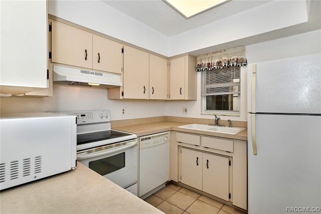 kitchen with light tile patterned flooring, cream cabinets, white appliances, and sink