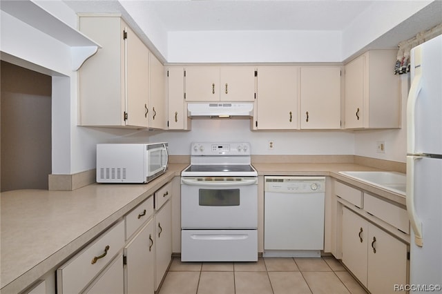 kitchen featuring cream cabinetry, white appliances, and light tile patterned floors