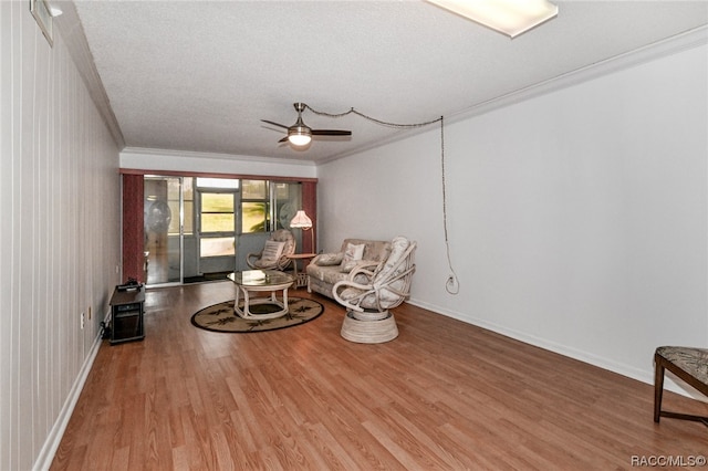 sitting room with crown molding, hardwood / wood-style floors, ceiling fan, and a textured ceiling