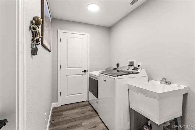 washroom featuring washer and dryer, wood finished floors, and baseboards