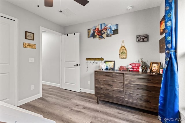 bedroom featuring wood finished floors, baseboards, and ceiling fan
