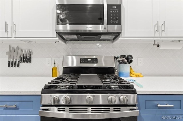 kitchen featuring appliances with stainless steel finishes, white cabinets, decorative backsplash, and blue cabinetry