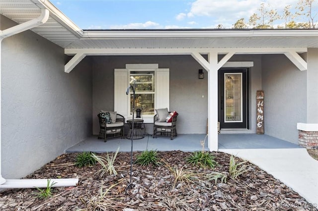 doorway to property featuring a porch and stucco siding