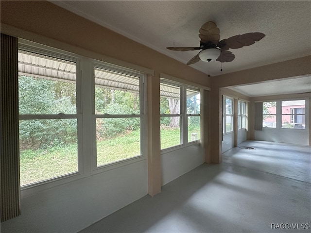 unfurnished sunroom featuring ceiling fan