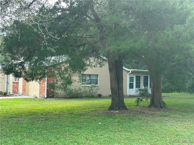 view of side of property featuring a lawn and a garage