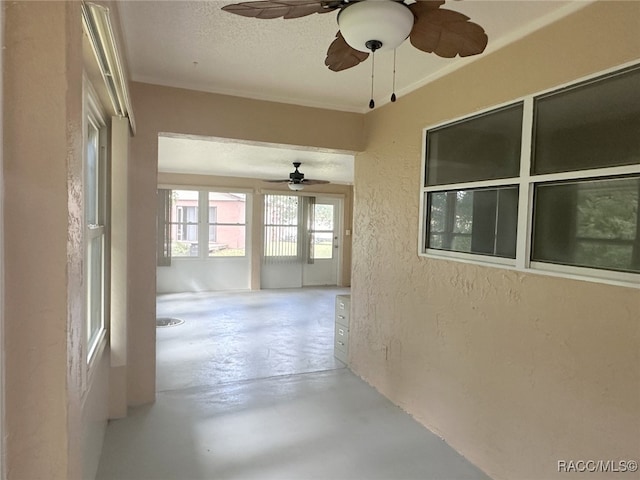 hall with a textured ceiling and concrete floors