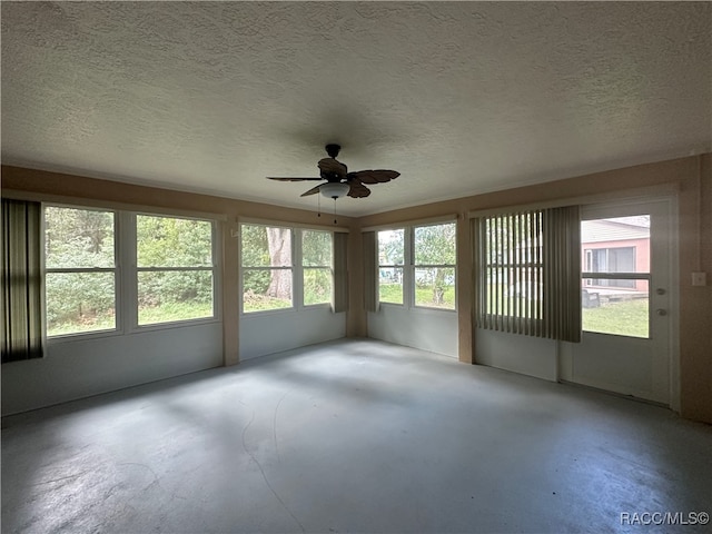 unfurnished sunroom with ceiling fan