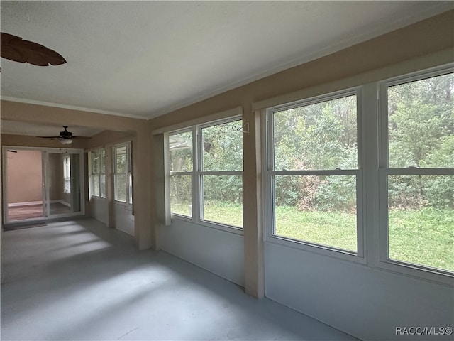 unfurnished sunroom featuring a wealth of natural light and ceiling fan