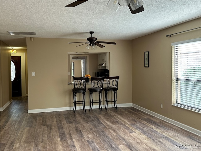 dining room with a textured ceiling and dark hardwood / wood-style floors