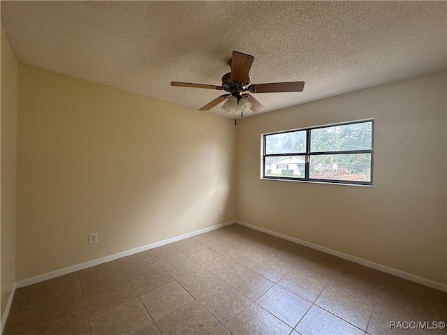 tiled empty room featuring ceiling fan and a textured ceiling