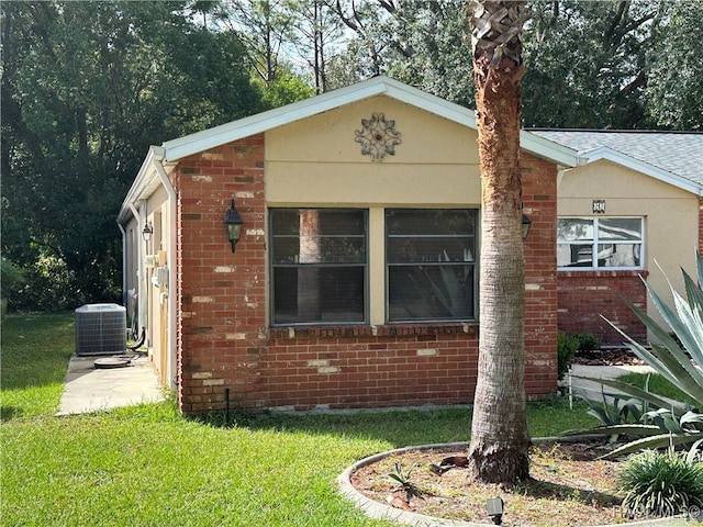 exterior space featuring a lawn and central AC