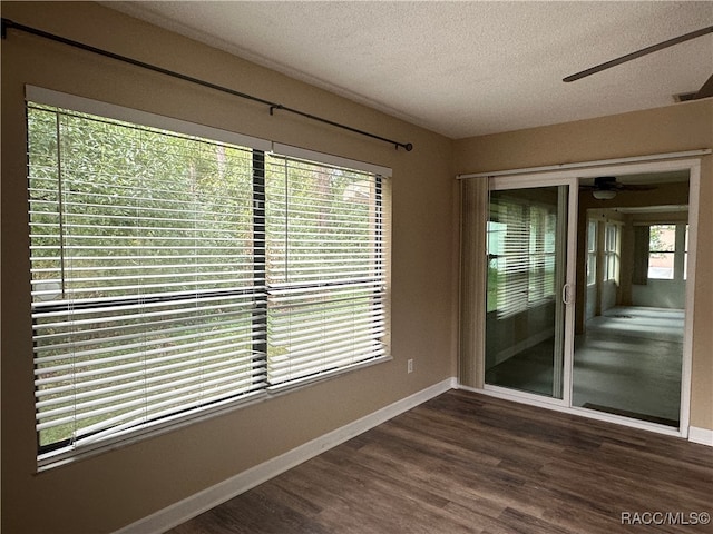 unfurnished room with a textured ceiling and dark hardwood / wood-style flooring