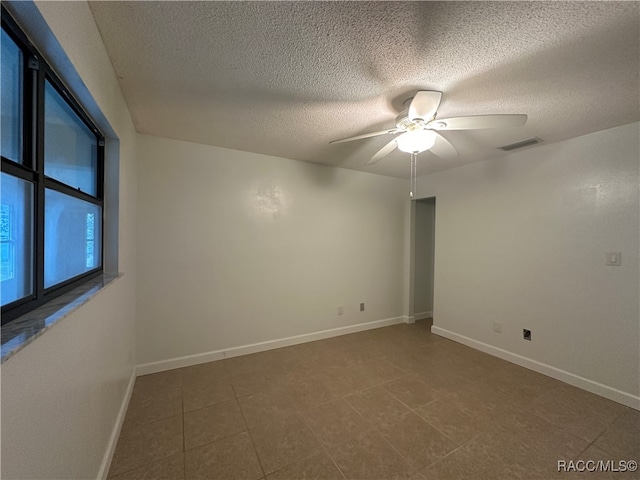 unfurnished room featuring ceiling fan and a textured ceiling