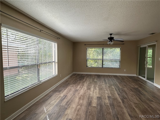 empty room with ceiling fan, dark hardwood / wood-style flooring, and a textured ceiling