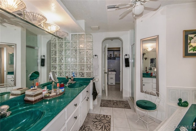 bathroom with tile patterned floors, a textured ceiling, vanity, a shower with door, and ceiling fan