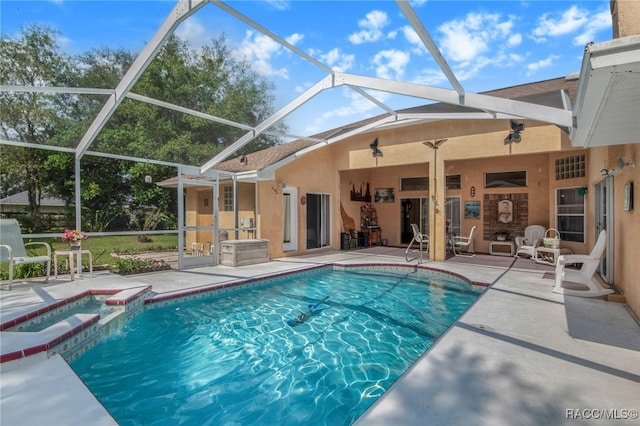 view of pool with a lanai, an in ground hot tub, and a patio