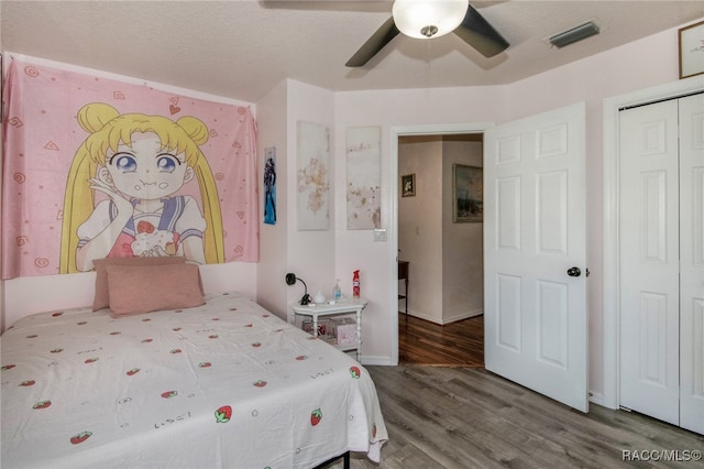 bedroom featuring wood-type flooring, a textured ceiling, a closet, and ceiling fan