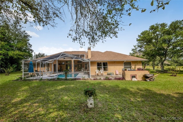 rear view of house with a patio, glass enclosure, and a lawn