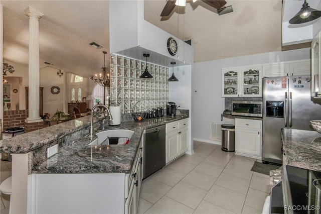 kitchen featuring ornate columns, white cabinetry, sink, stainless steel appliances, and lofted ceiling