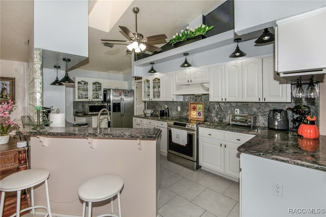 kitchen featuring custom exhaust hood, kitchen peninsula, appliances with stainless steel finishes, a kitchen bar, and white cabinetry