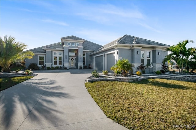 view of front of home with a front yard and a garage