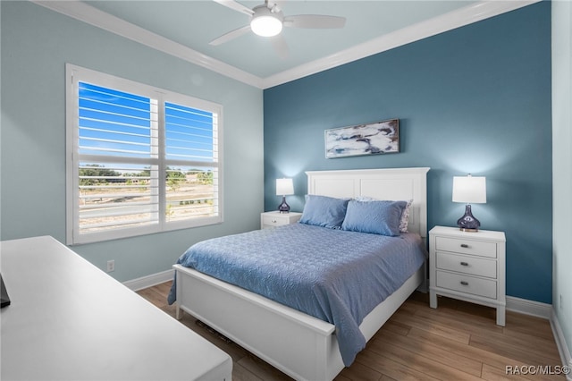 bedroom with hardwood / wood-style floors, ceiling fan, and crown molding